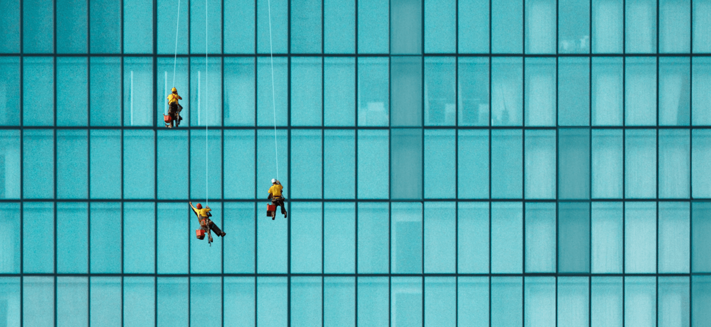 Drei Fensterreiniger an einem Hochhaus